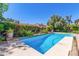 Private backyard oasis featuring a sparkling blue pool surrounded by lush landscaping at 5325 W Desert Hills Dr, Glendale, AZ 85304