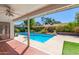 Back patio with a clear blue swimming pool and surrounding foliage under a covered patio at 5325 W Desert Hills Dr, Glendale, AZ 85304