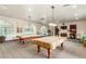Billiard room with two pool tables, arched windows, and seating under decorative lighting at 5450 E Deer Valley Dr # 2003, Phoenix, AZ 85054