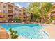Sparkling community pool with cascading waterfall feature, surrounded by lush palm trees and lounge chairs at 5450 E Deer Valley Dr # 2003, Phoenix, AZ 85054