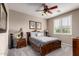 Comfortable bedroom with neutral walls, ceiling fan, window with plantation shutters and wood furniture at 5622 W Cavedale Dr, Phoenix, AZ 85083