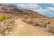 Scenic walking path winding through the desert landscape with a mountain backdrop under a partly cloudy sky at 5622 W Cavedale Dr, Phoenix, AZ 85083