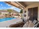 Relaxing covered patio overlooking a beautiful backyard with a custom pool and desert landscape at 6372 W Hill Ln, Glendale, AZ 85310