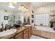 Elegant bathroom featuring double sinks, granite countertops, a soaking tub, and a glass-enclosed shower at 6372 W Hill Ln, Glendale, AZ 85310