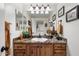 Charming bathroom featuring granite countertops, custom wood cabinets, and decorative sconce lighting at 6372 W Hill Ln, Glendale, AZ 85310
