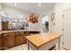 Open kitchen with wood cabinets, granite countertops, and a hanging pot rack, flowing into the dining area at 6372 W Hill Ln, Glendale, AZ 85310