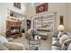 Cozy living room featuring a stone fireplace, large window, and comfortable seating arrangements at 6372 W Hill Ln, Glendale, AZ 85310