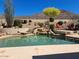 Backyard pool with a stone waterfall feature and desert landscaping create a relaxing outdoor oasis at 6372 W Hill Ln, Glendale, AZ 85310