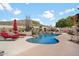 Backyard oasis featuring a luxurious pool, rock waterfall, spa, and desert landscaping at 6372 W Hill Ln, Glendale, AZ 85310