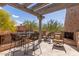 Outdoor stone balcony with a fire place and overhead awning with four chairs and table at 7600 E Golden Eagle Cir, Gold Canyon, AZ 85118