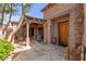 Inviting entryway featuring a solid wood door, travertine tile flooring, and a covered patio area at 7600 E Golden Eagle Cir, Gold Canyon, AZ 85118