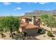 Charming Tuscan-style home with a stone chimney and lush landscaping against a mountain backdrop at 7600 E Golden Eagle Cir, Gold Canyon, AZ 85118
