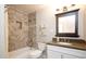 Well-lit bathroom with a shower-tub combo, granite countertop, and elegant tile work at 8408 E Lewis Ave, Scottsdale, AZ 85257