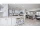 Open kitchen with white cabinets, granite countertops, island seating, and connecting living room at 8408 E Lewis Ave, Scottsdale, AZ 85257