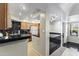 A well-lit kitchen with wooden cabinets, black countertops, and modern appliances at 8787 E Mountain View Rd # 2016, Scottsdale, AZ 85258