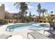 Exterior view of the community pool area and spa, with lounge chairs for tanning and mature palm trees in the background at 8787 E Mountain View Rd # 2016, Scottsdale, AZ 85258