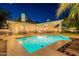 Expansive backyard with a sparkling pool and large windows offering seamless indoor-outdoor living experience at night at 9041 N 46Th St, Phoenix, AZ 85028