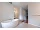 Stylish bathroom featuring a modern soaking tub, vanity with mirror, and a doorway leading to another area at 9041 N 46Th St, Phoenix, AZ 85028