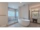 Modern bathroom with a soaking tub, glass-enclosed shower, and vanity with a makeup table and great lighting at 9041 N 46Th St, Phoenix, AZ 85028