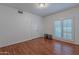 Bedroom showcasing wood floors, double door closet, and window with plantation shutters at 9041 N 46Th St, Phoenix, AZ 85028