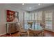 A dining room with a glass table is brightly illuminated by natural light from windowed walls at 9041 N 46Th St, Phoenix, AZ 85028