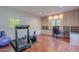 Bright exercise room with built-in cabinets, desk, and exercise equipment on wood floors at 9041 N 46Th St, Phoenix, AZ 85028