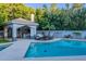 Inviting pool with outdoor kitchen and lounging area surrounded by lush greenery at 9041 N 46Th St, Phoenix, AZ 85028