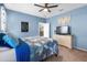 This bedroom has blue walls, carpeted floors, a ceiling fan, and a mounted TV at 4053 N 308Th Ln, Buckeye, AZ 85396