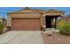 Charming single-story home featuring a brown garage door and desert landscaping at 4053 N 308Th Ln, Buckeye, AZ 85396