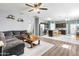 Open-concept living room featuring a gray sectional, wood floors, and seamless flow to the kitchen area at 4053 N 308Th Ln, Buckeye, AZ 85396