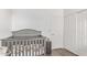 Cozy Bedroom with a gray crib, a small side table, a closet and white door at 4302 E Mountain Vista Dr, Phoenix, AZ 85048