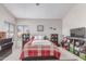 Bedroom featuring a bright, red and white plaid bedspread, and warm natural lighting at 4302 E Mountain Vista Dr, Phoenix, AZ 85048