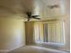 Bedroom featuring a ceiling fan, large window with blinds, and textured walls, offering natural light at , Tempe, AZ 85282