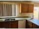 Well-lit kitchen includes a stainless steel sink, neutral countertops, and light wood cabinets, perfect for cooking at , Tempe, AZ 85282