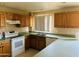 Functional kitchen featuring light wood cabinets, white appliances, and neutral countertops for meal preparation at , Tempe, AZ 85282