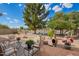 Relaxing backyard featuring a lake view, gravel landscaping, lush trees, and comfortable patio seating at 10804 W Mohawk Ln, Peoria, AZ 85373