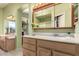 Bathroom featuring wooden cabinets, updated lighting, and a double vanity at 10804 W Mohawk Ln, Peoria, AZ 85373