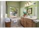 Relaxing bathroom with a soaking tub, window, and a stylish vanity area with plenty of storage at 10804 W Mohawk Ln, Peoria, AZ 85373