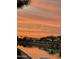 Scenic lake view with colorful sky and lights on houses, creating a serene nighttime atmosphere at 10804 W Mohawk Ln, Peoria, AZ 85373