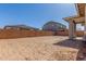 Expansive dirt backyard enclosed by a brick wall and partial view of the house at 21829 E Bonanza Ct, Queen Creek, AZ 85142