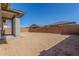Large, dirt backyard enclosed by a brick wall and partial view of the covered patio at 21829 E Bonanza Ct, Queen Creek, AZ 85142