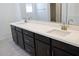 Bathroom vanity with double sinks, dark wood cabinets and quartz countertops at 2442 W Rowel Rd, Phoenix, AZ 85085