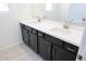 Bathroom vanity with double sinks, dark cabinetry, and white countertops for a modern look at 2442 W Rowel Rd, Phoenix, AZ 85085