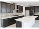 Spacious kitchen featuring dark wood cabinets, stainless steel appliances, and a large kitchen island with seating at 2442 W Rowel Rd, Phoenix, AZ 85085