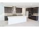 Modern kitchen with dark wood cabinets, stainless steel appliances, and large white island at 2442 W Rowel Rd, Phoenix, AZ 85085