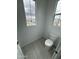 Powder room featuring a toilet, tiled floors, and natural light at 2470 W Rowel Rd, Phoenix, AZ 85085