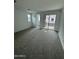 Bright living room with neutral walls, plush gray carpeting, and access to a balcony at 2470 W Rowel Rd, Phoenix, AZ 85085