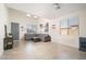 Inviting living room with neutral tile, comfortable sectional sofa, and decorative shelving near the entry at 3547 N 145Th Ave, Goodyear, AZ 85395