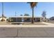 Single-story home boasts a charming curb appeal with a manicured lawn, palm tree, and gray exterior at 5455 E Baltimore St, Mesa, AZ 85205