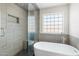 Contemporary bathroom features a glass shower, soaking tub, and unique window design at 1165 E Avenida Kino --, Casa Grande, AZ 85122